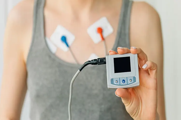 Immagine di un paziente che tiene in mano un dispositivo per l`elettrocardiogramma Holter.